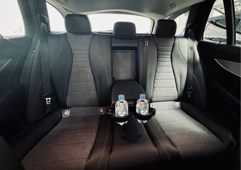 Ásványvíz a Mercedes-Benz E-osztály hátsó kartámaszának pohártartóiban