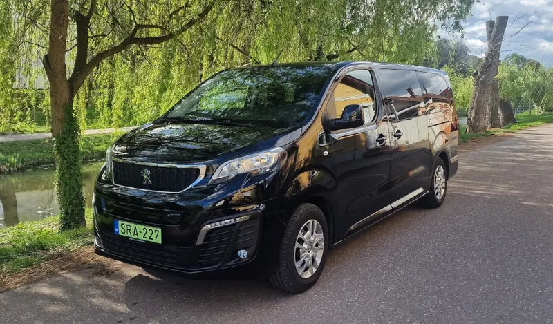 Fekete elektromos Peugeot e-Traveller zöld rendszámmal a vízparton